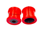 Two red polyurethane control arm bushings side by side, showing the outer shell and inner bore | Wrench Haus