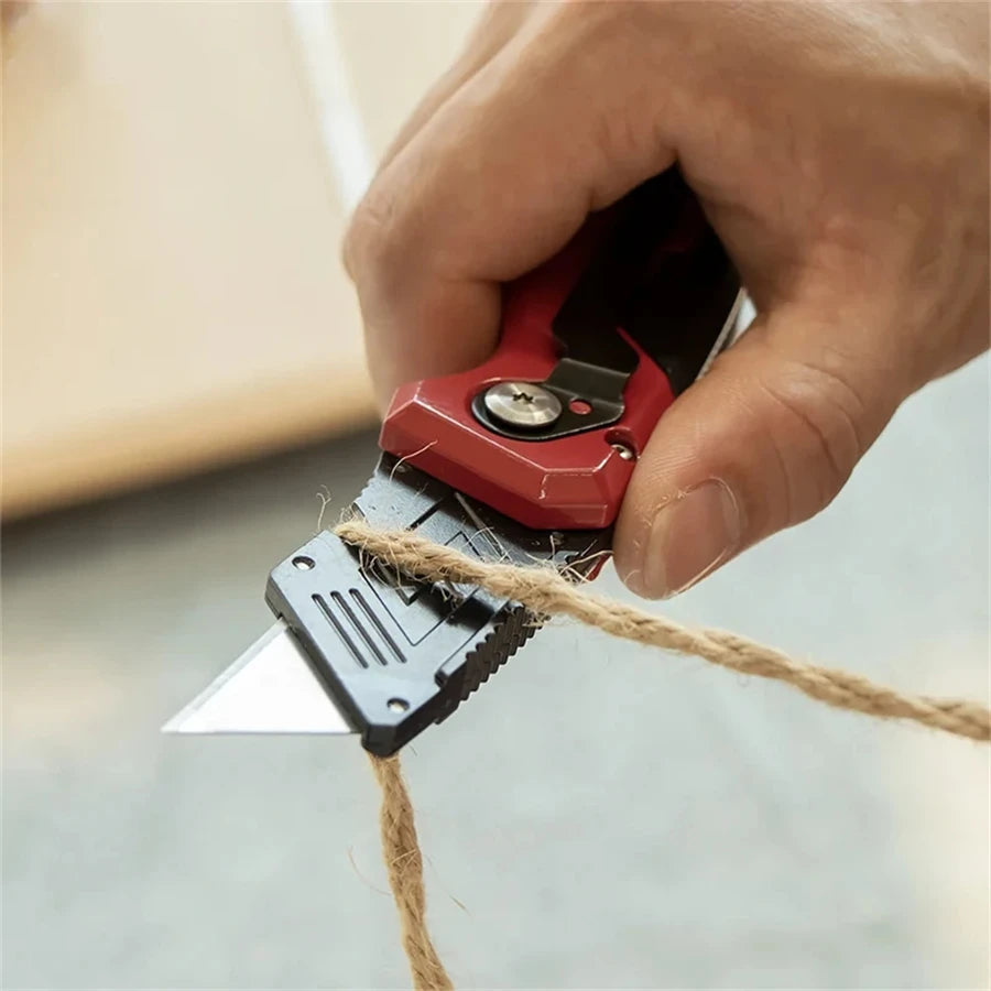 Folding Utility Knife - Red utility knife in use cutting rope, demonstrating clean single-blade cutting action | Wrench Haus
