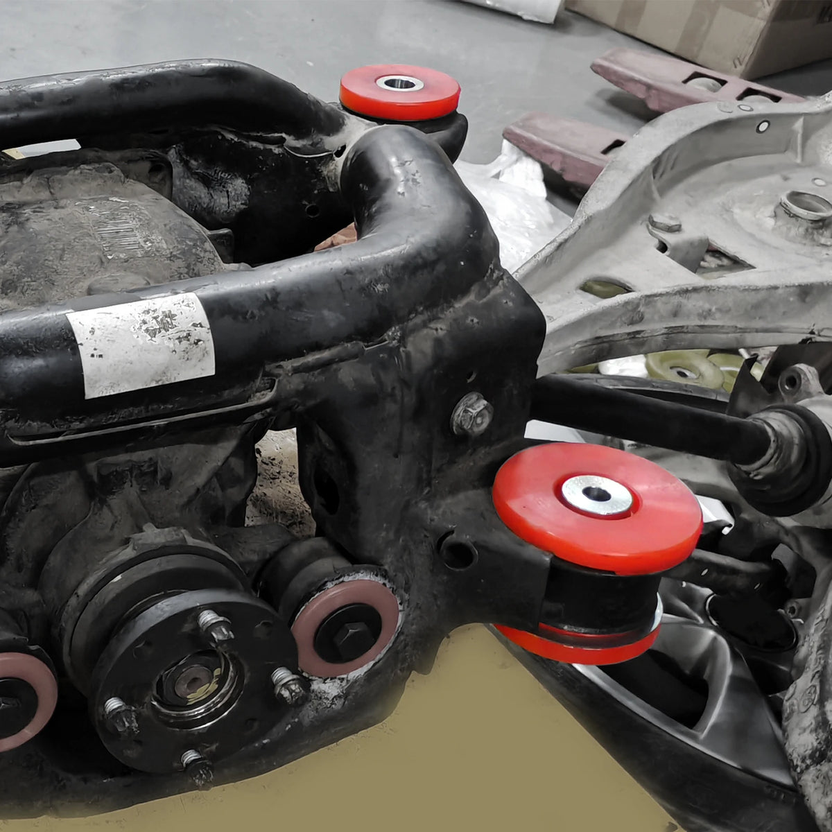 Polyurethane rear subframe bushings, red, installed on rear subframe | Wrench Haus