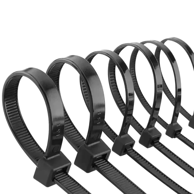 Black Nylon Zip Ties - Five black cable ties fanned and looped showing locking head and serrated strap | Wrench Haus
