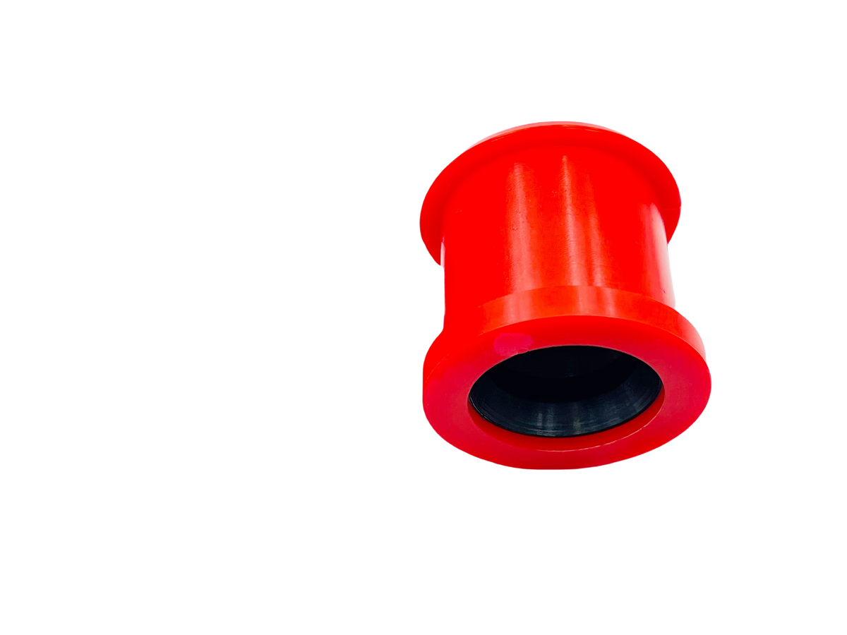 Large red polyurethane control arm bushing on a black background | Wrench Haus