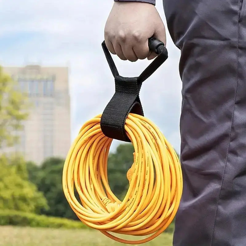 Extension Cord Organizer Strap In Use - Heavy-Duty Handle Carrying Coiled Yellow Cord Outdoors | Wrench Haus
